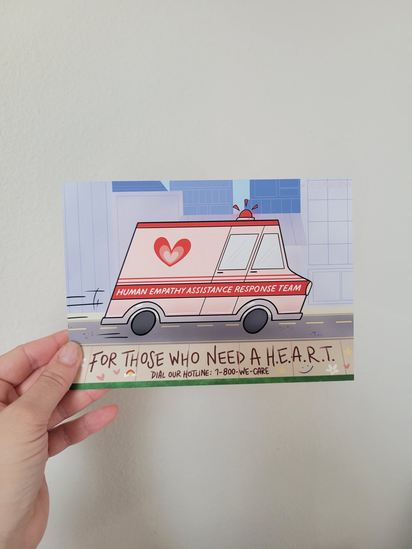 Hand holding a card with a graphic of a van and text on a plain background