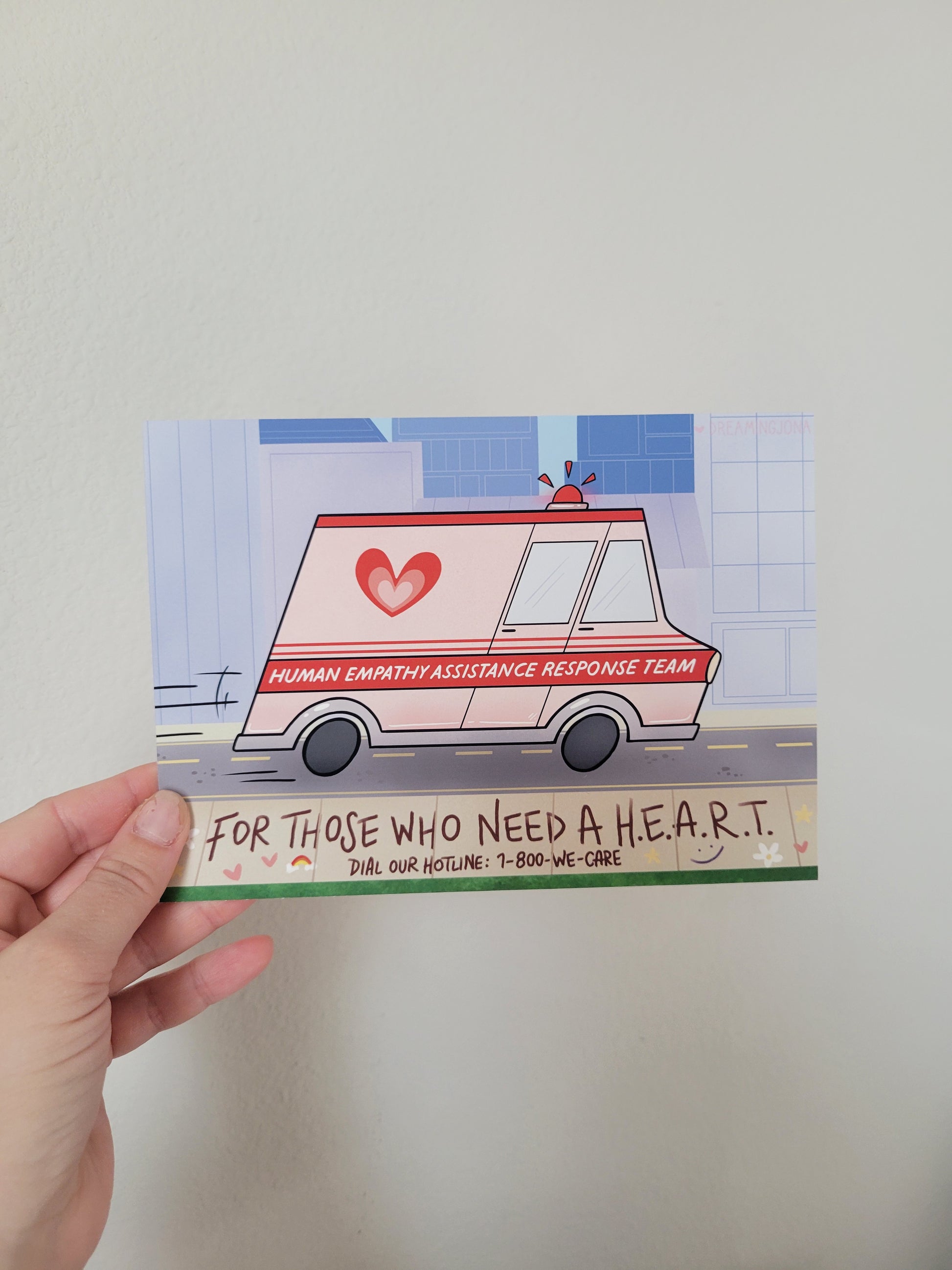 Hand holding a card with a graphic of a van and text on a plain background