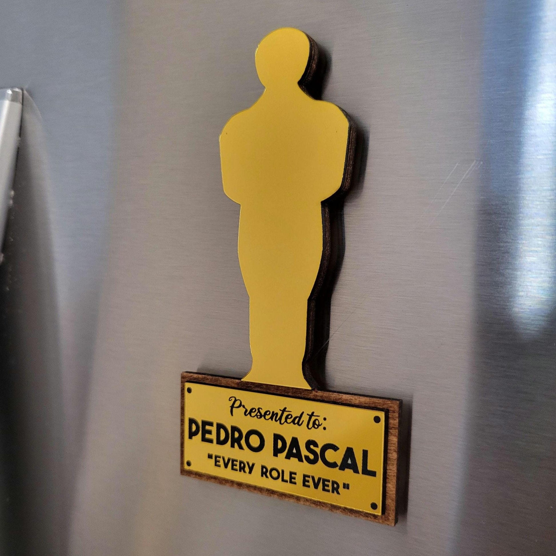 brushed gold silhouette of a statue on a fridge with text