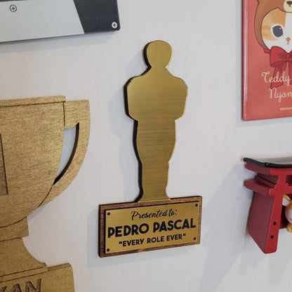 Gold Oscar statue cutout with 'Presented to Pedro Pascal Every Role Ever' text on a fridge