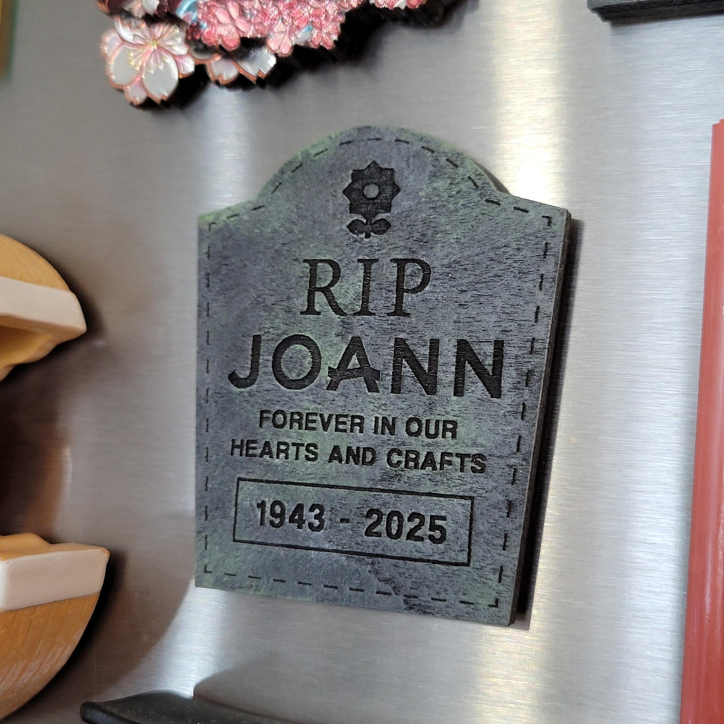 Memorial magnet shaped like a tombstone with text on a fridge