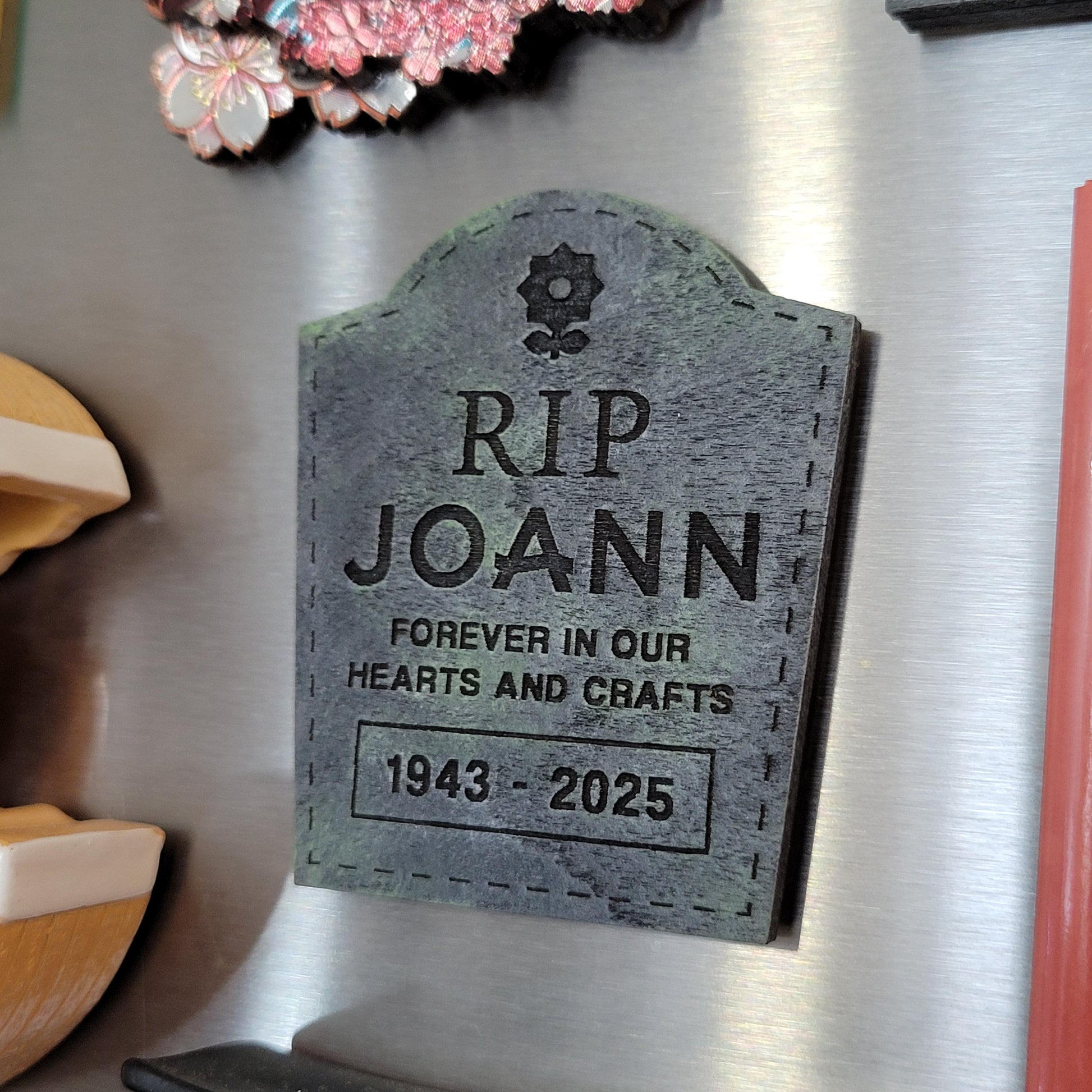 Memorial magnet shaped like a tombstone with text on a fridge
