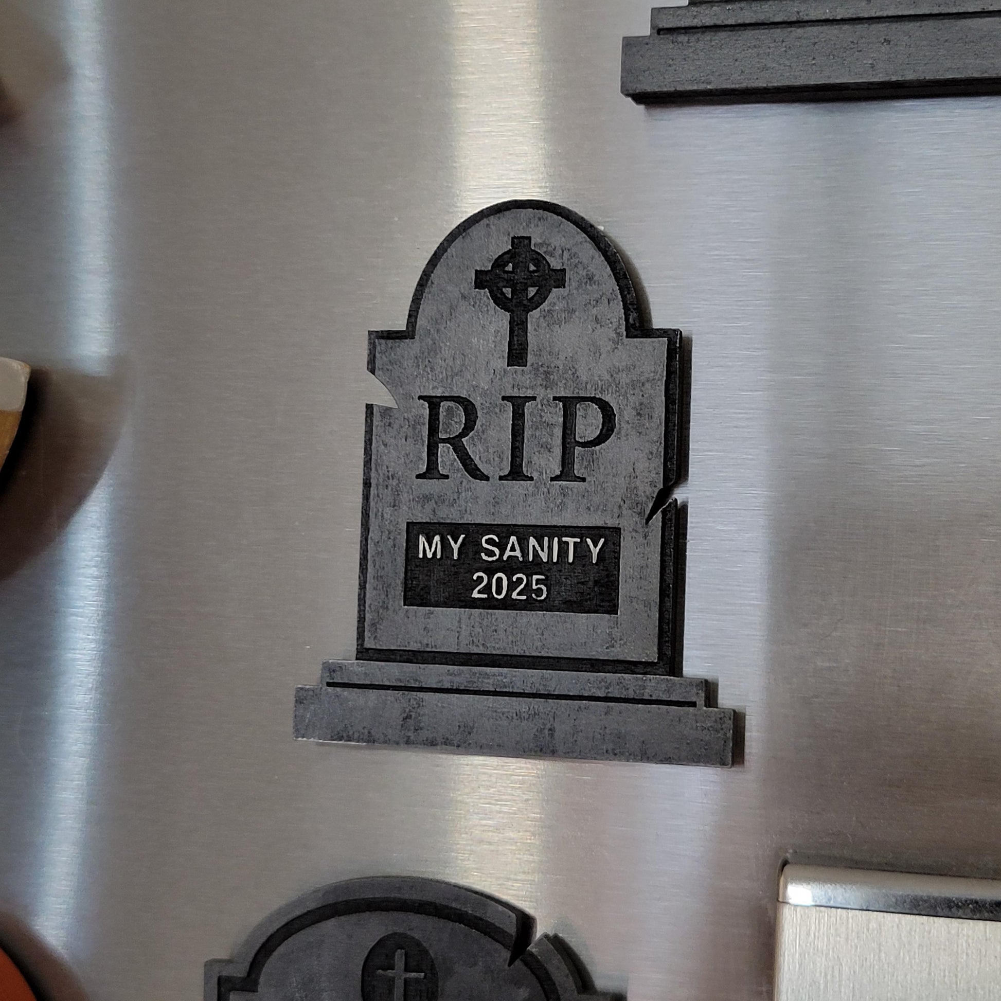 gray tombstone magnet on fridge