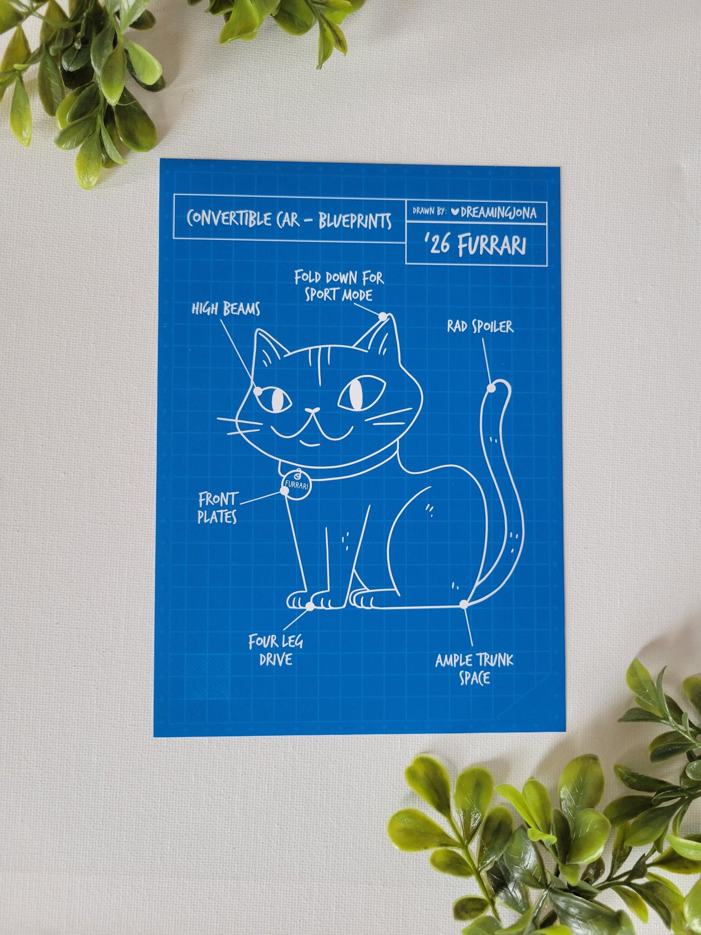 Blueprints of a cat design on a white background with green leaves.