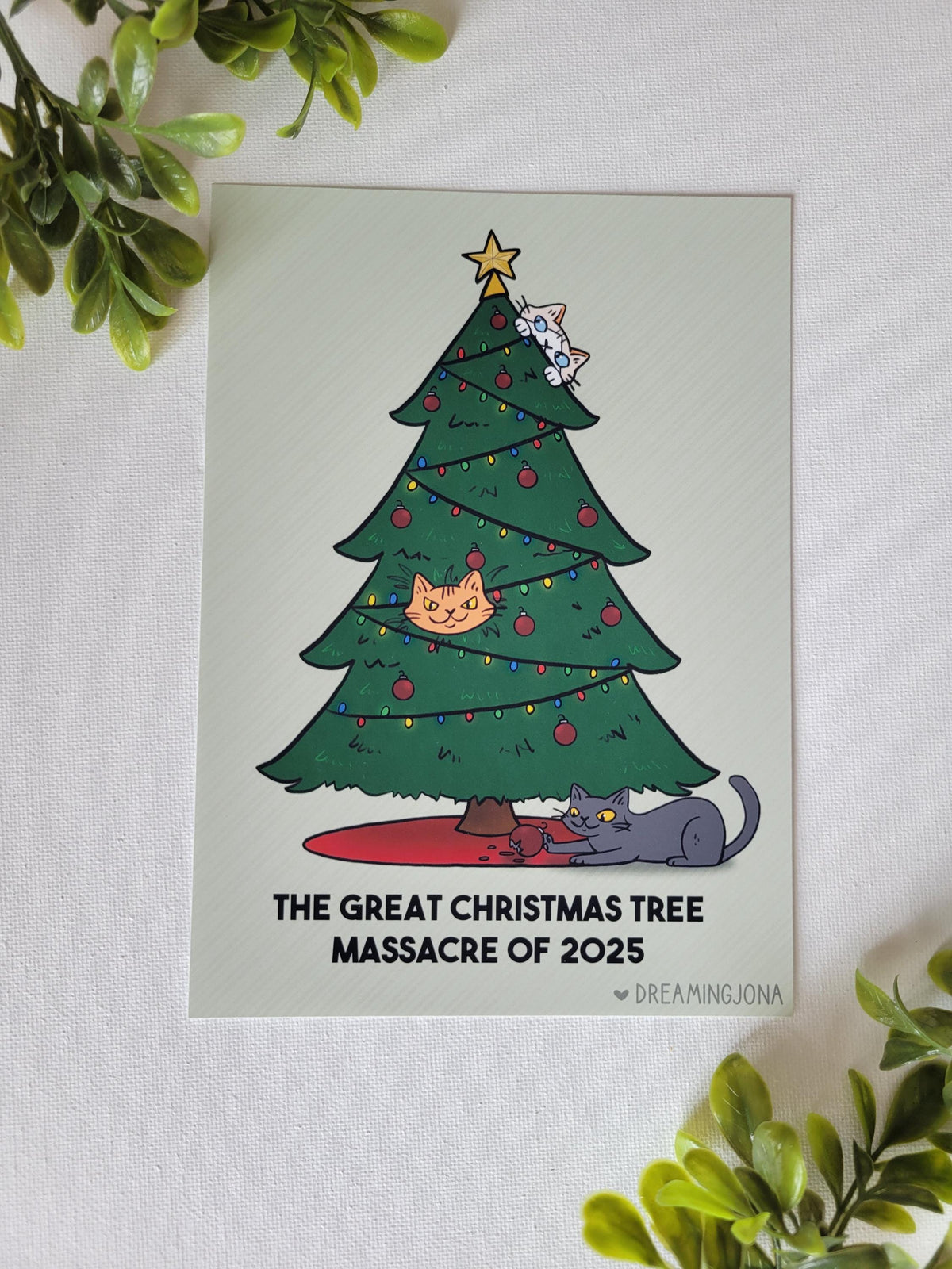 Illustration of a Christmas tree with cats on a light green background, surrounded by green leaves.