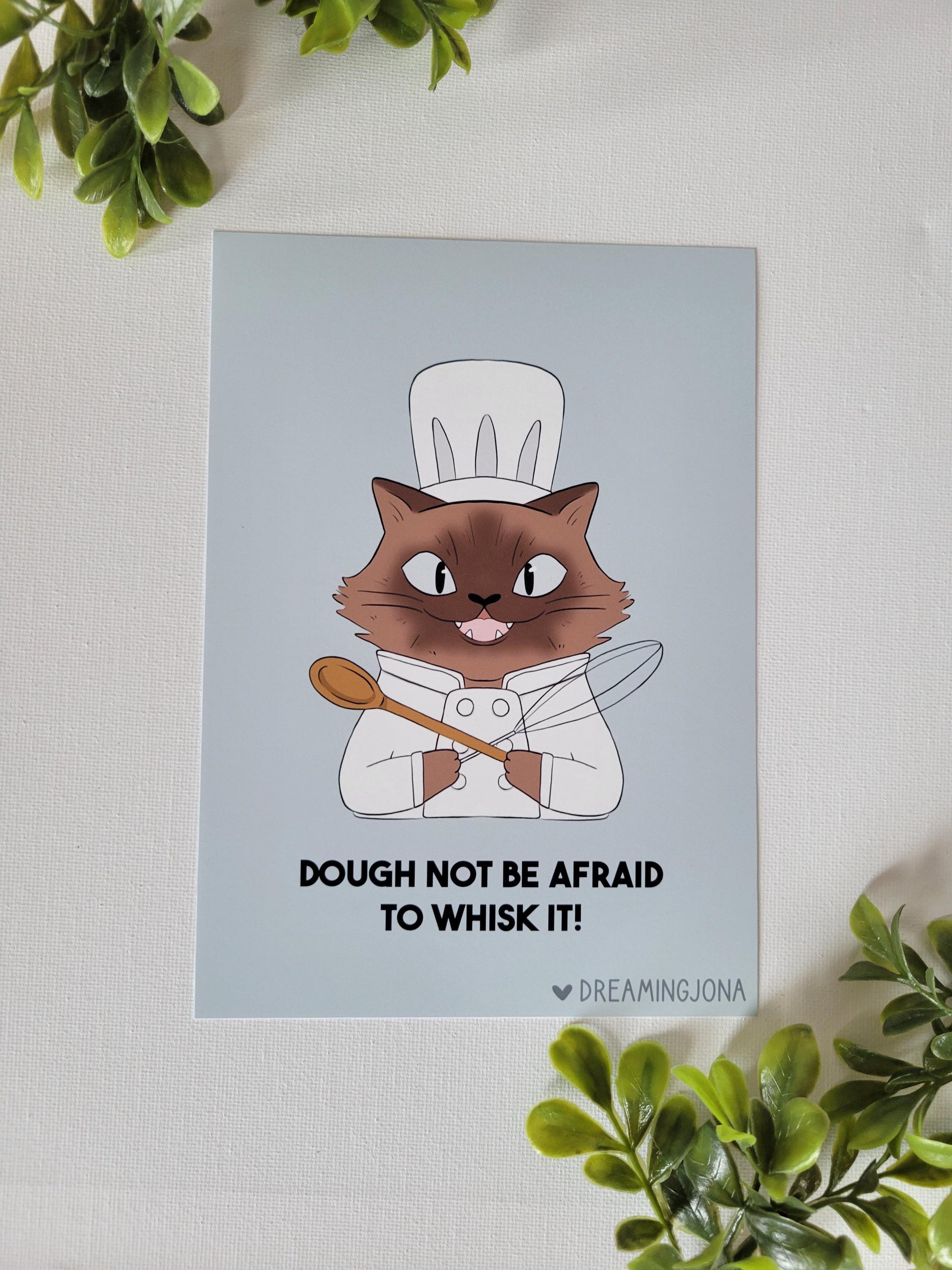 Siamese cartoon cat chef holding a wooden spoon with text on a light blue background, surrounded by green plants.