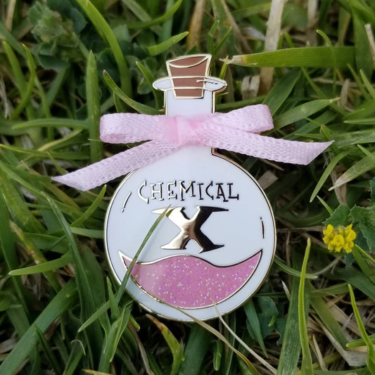 Decorative bottle pin with pink ribbon on grass