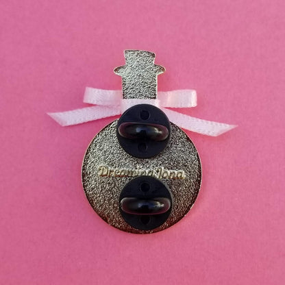 Decorative pin backing with a bow on a pink background