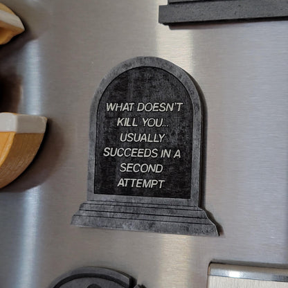 Decorative tombstone sign on a refrigerator with humorous text.