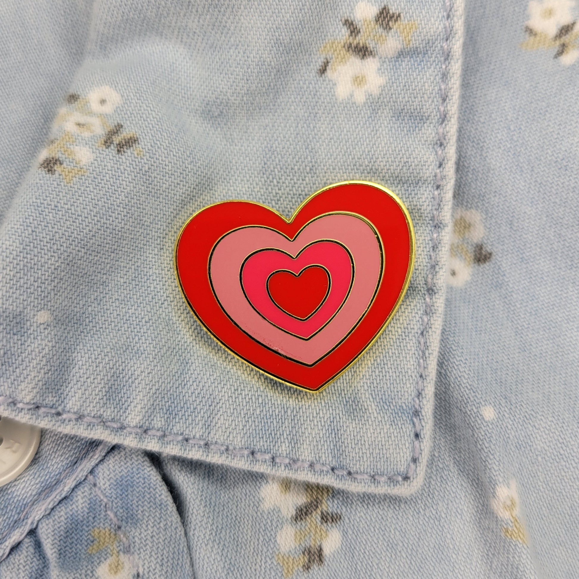 Heart-shaped pin on a denim jacket with floral patterns
