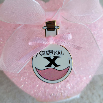 Pink decorative bottle pin with a label on a pink background
