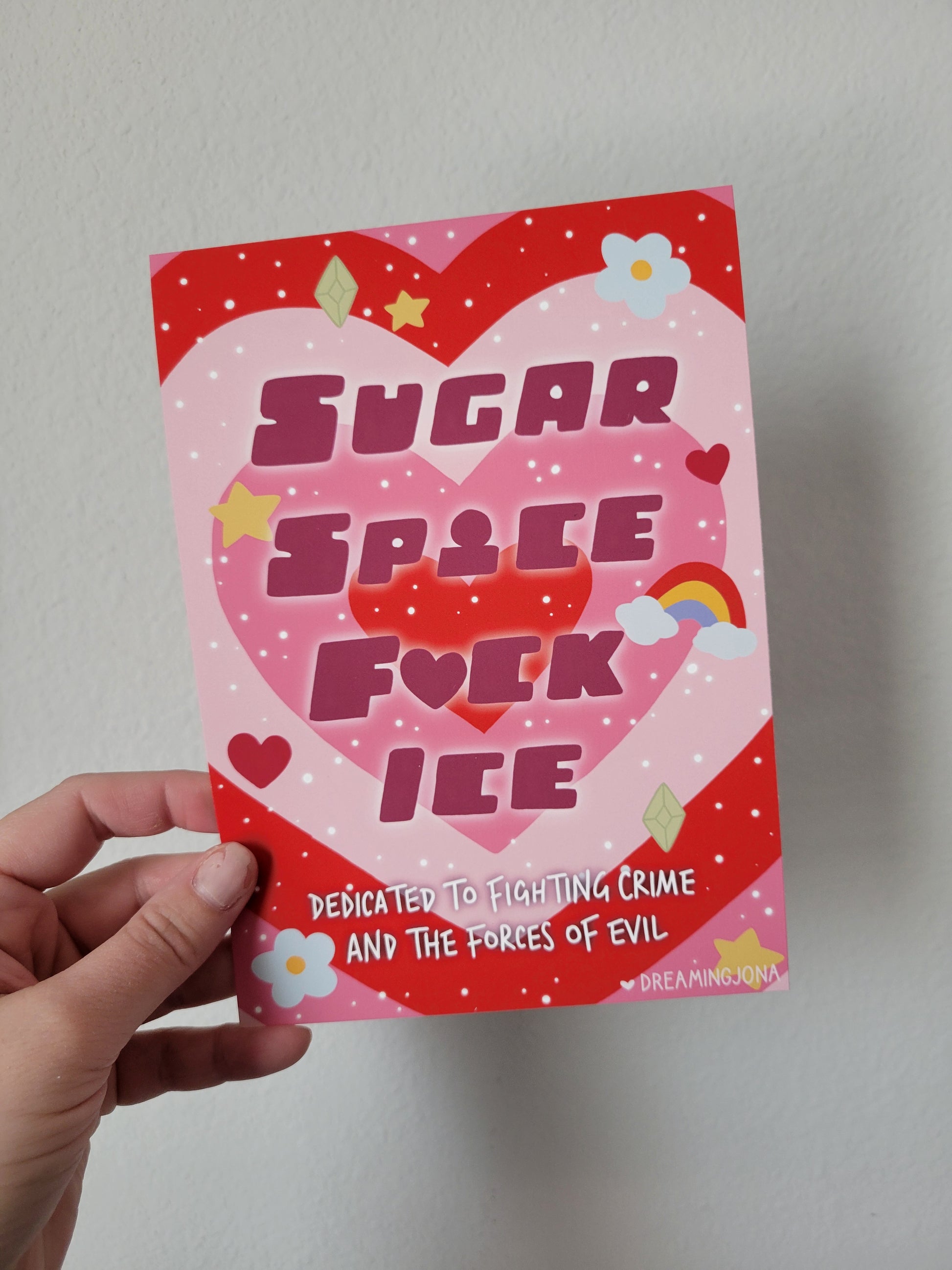 Hand holding a red and pink card with text and graphics on a plain background
