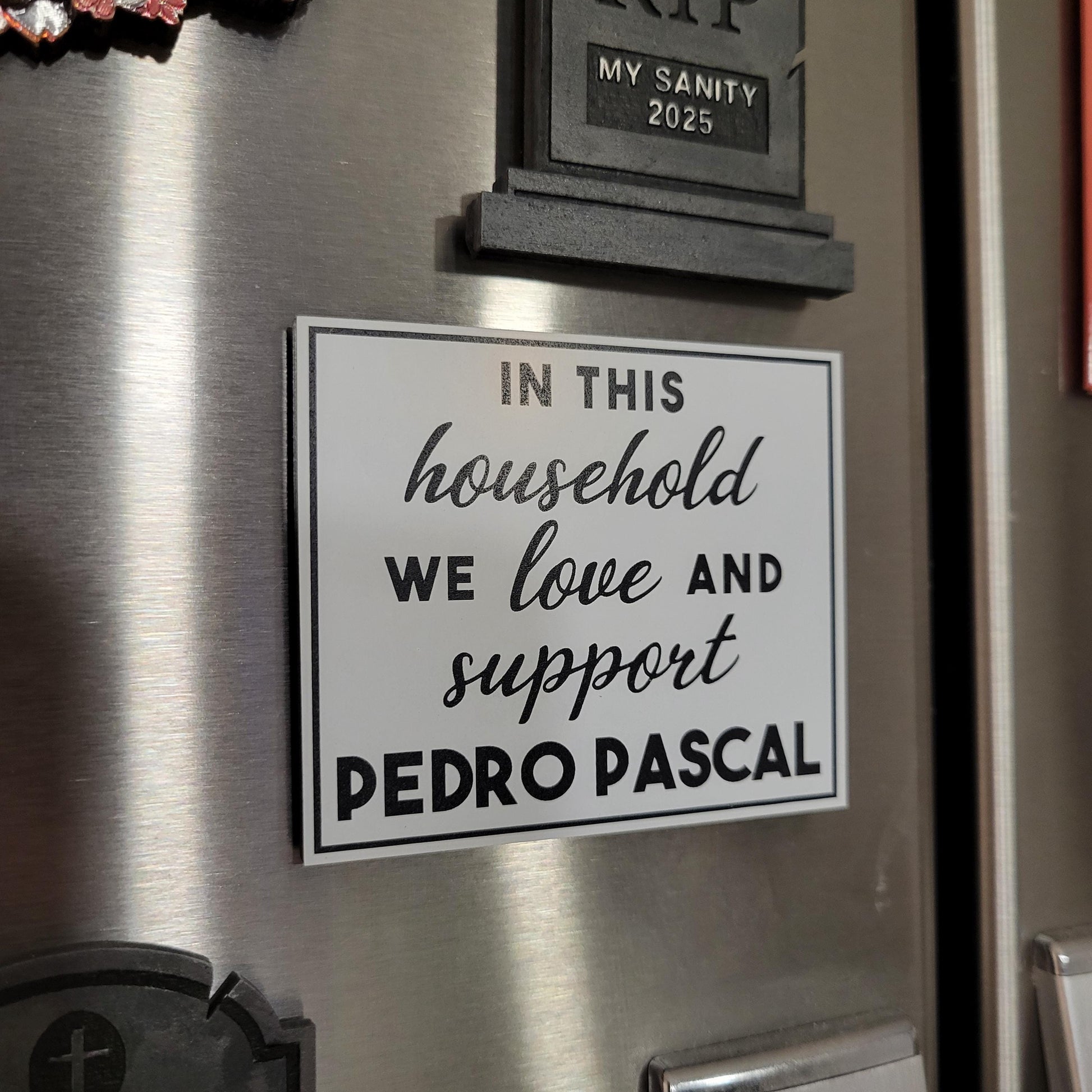 Decorative sign on a refrigerator with text about supporting Pedro Pascal.